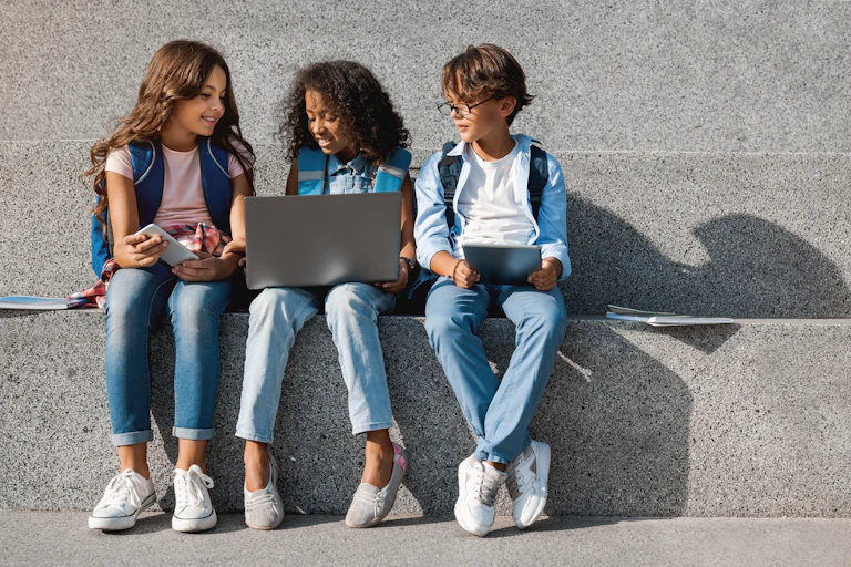 Three children looking at laptop and tablet