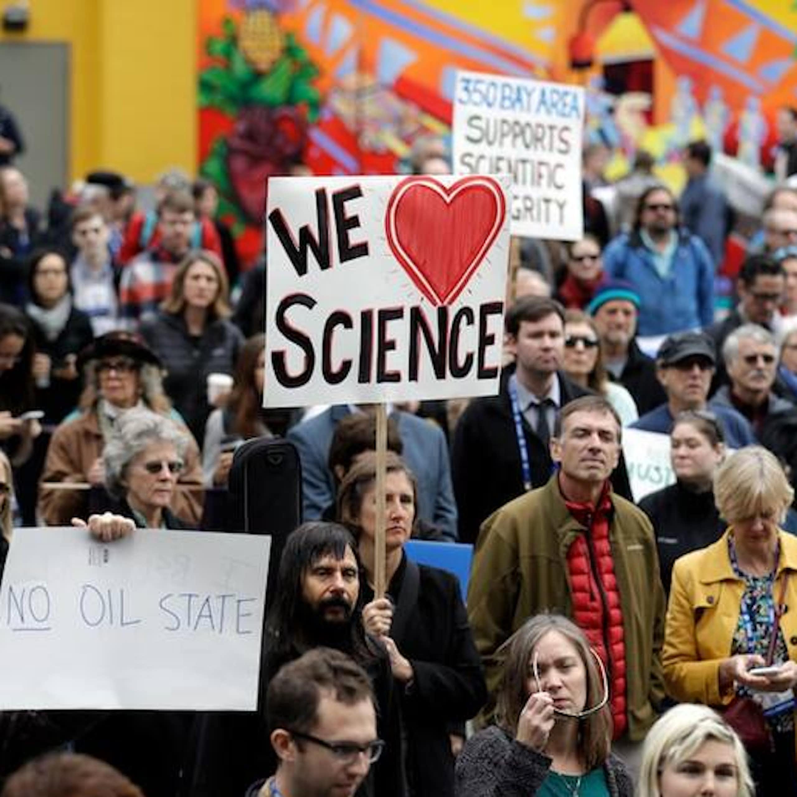 A crowd marching and holding signs saying We Love Science