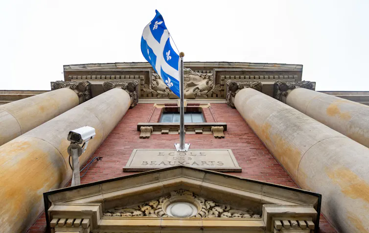 La bandera azul y blanca cuelga sobre un edificio con postes de piedra.