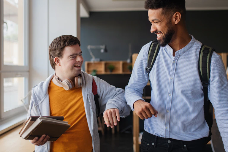 Two young men seen bumping elbows and smililng.