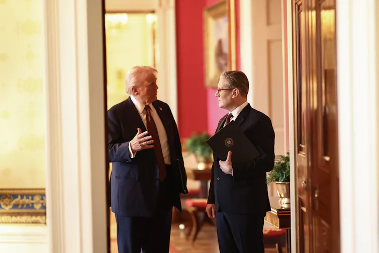 Trump speaks to Starmer while the two are stopped in a doorway inside the White House