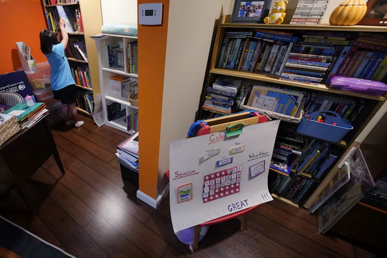 a child grabs a book from a bookshelf in a room full of books