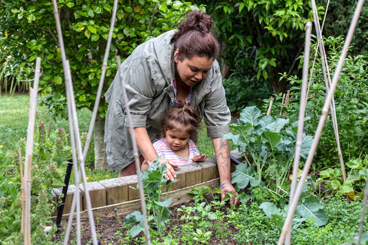 A woman with her daughter doing gardening.