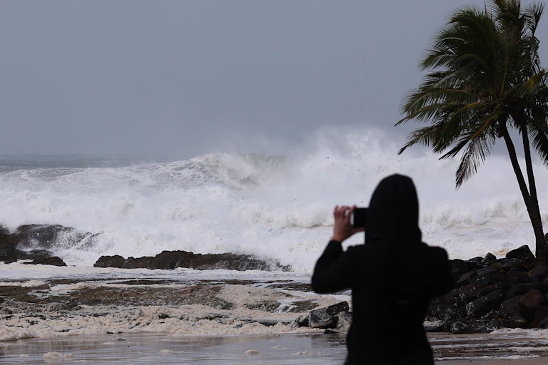 woman photographing stormy sea