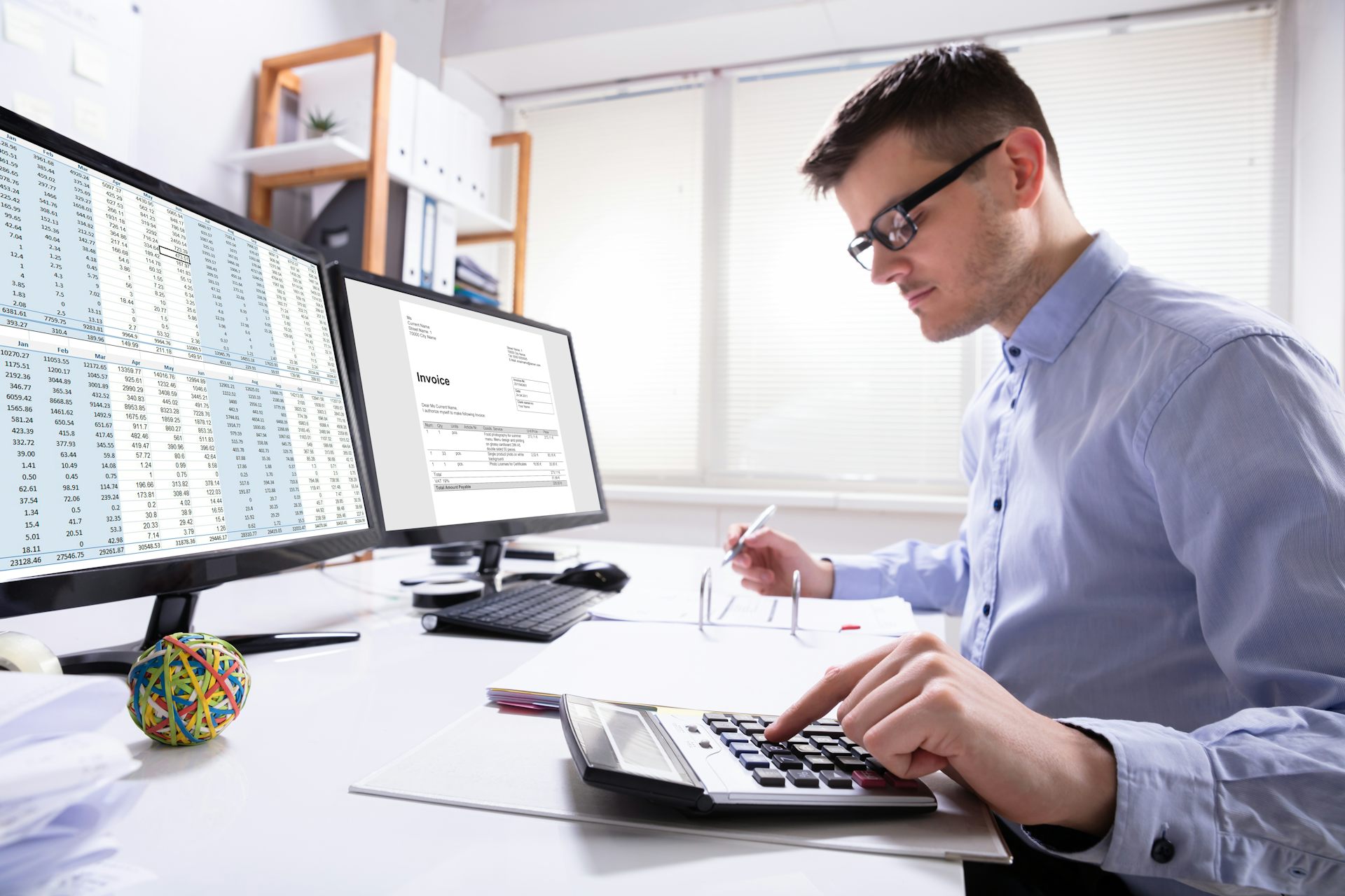 Man sitting at desk with calculators