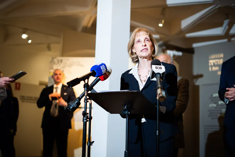 An older woman speaks at a podium.