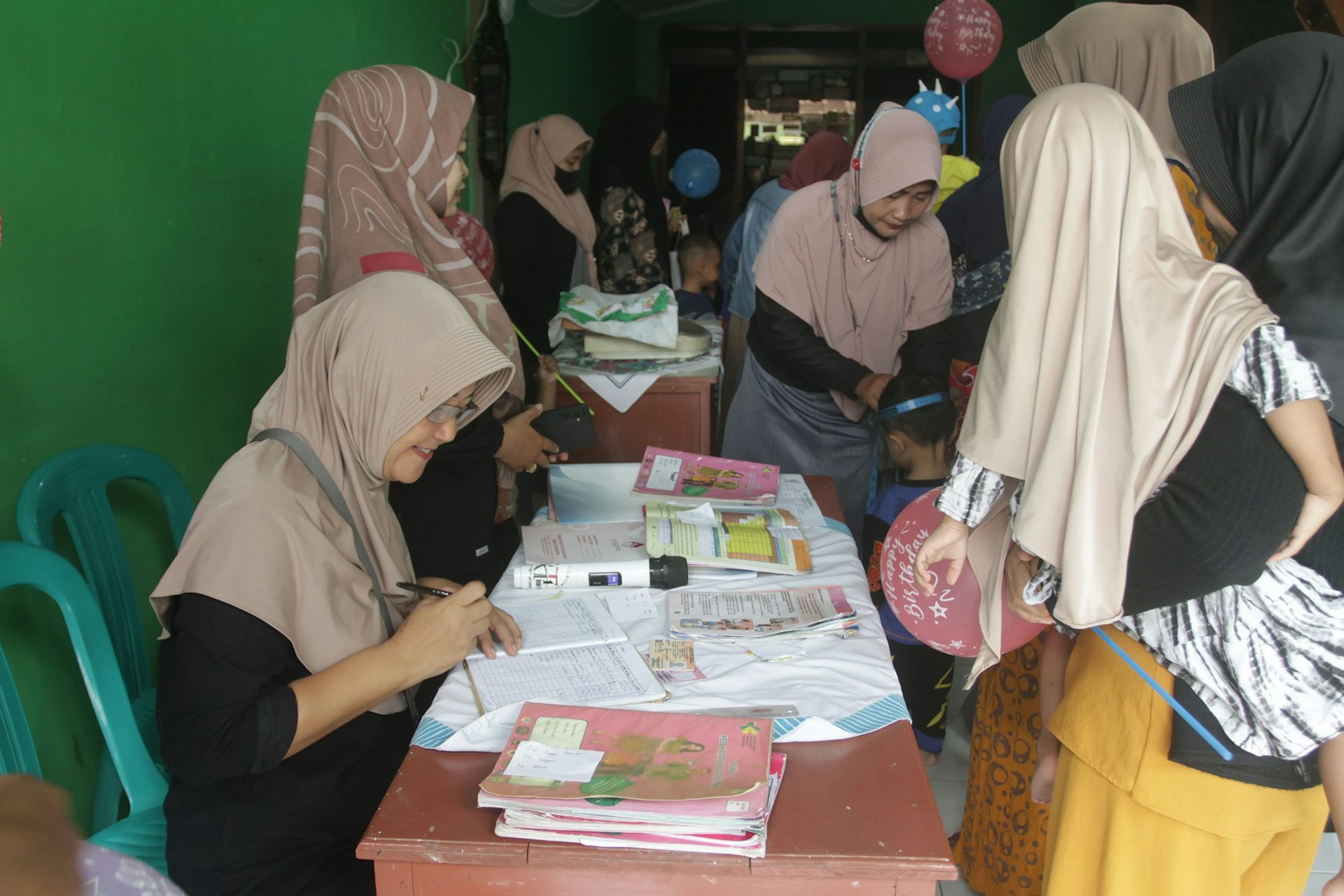 Kader kesehatan saat membantu layanan imunisasi polio anak.
