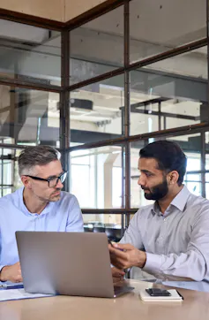 Two businessmen talking with a laptop