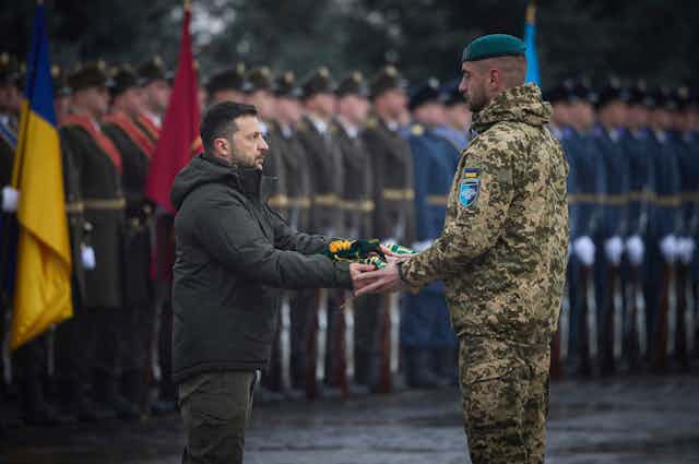 Volodymyr Zelensky hands a medal to a Ukrainian soldier during a ceremony in Kyiv, December 2024.