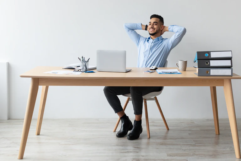 Un homme assis à son bureau avec une position décontractée