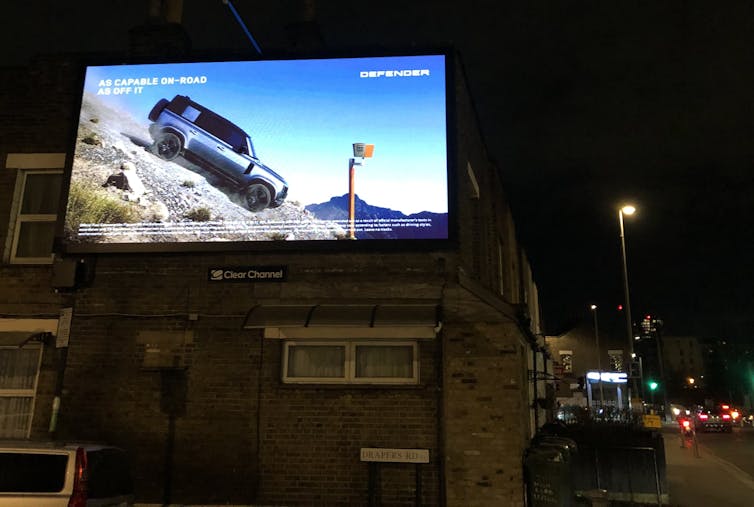 Large car billboard on side of house