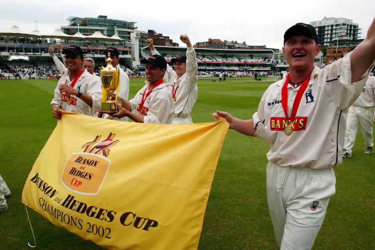 Cricket players with 'benson and hedges cup' flag