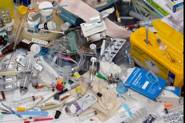 A collection of used, single-use medical plastic items — such as syringes, wipes, medicine containers and gloves.
