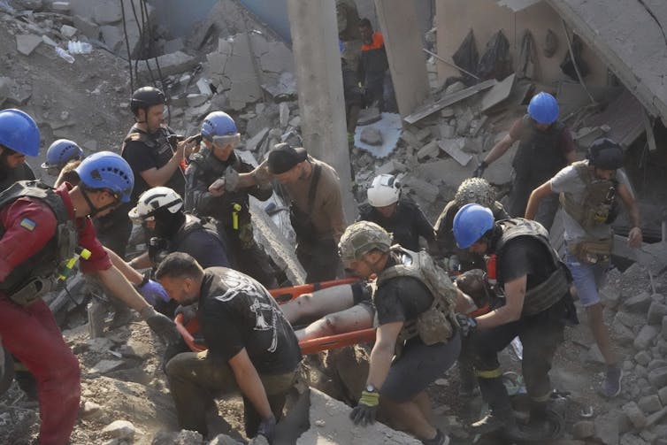 Emergency workers carry a man out of rubble.