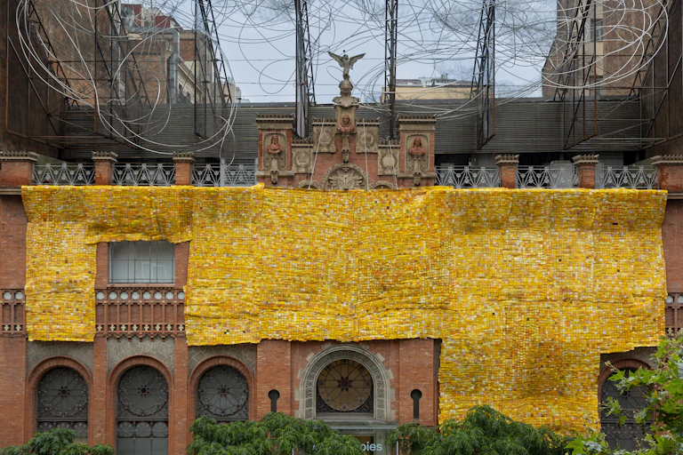 Façade du Museu Tàpies de Barcelone en 2024, avec l'installation « Beyond The Skin » de Serge Attukwei Clottey.