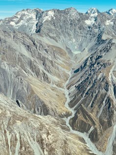 An aerial view of a mountain glacier and its outflow stream.