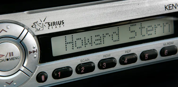 A wide radio player as might be seen in a car shows the words 'Howard Stern.'