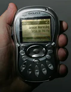A small radio held in a hand.