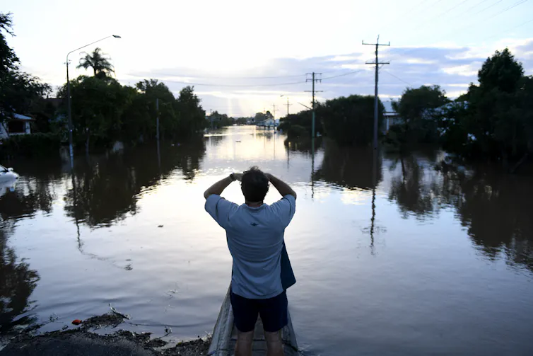 Man watches rising flood waters
