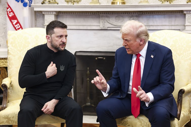 Two men sit on seats, looking angry