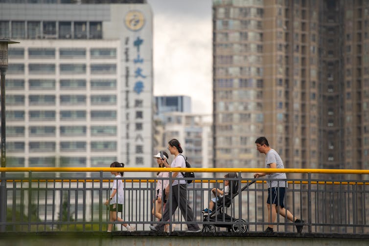 A family walks across a bridge in the city of Shenzhen, China.