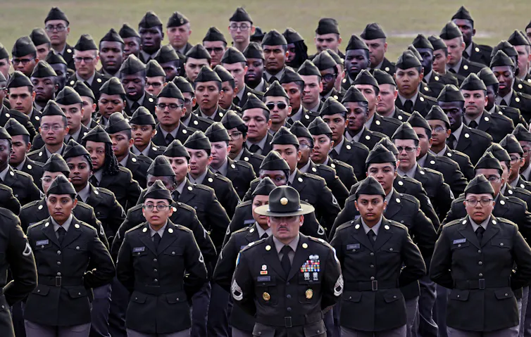 A group of people in military uniforms stand in formation.