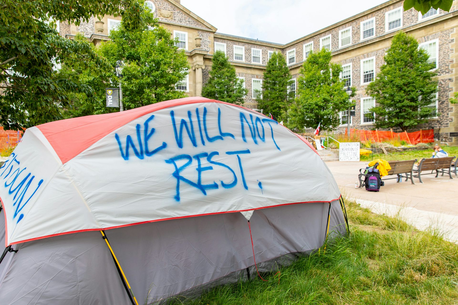 A tent with paint on it that reads 'we will not rest.'