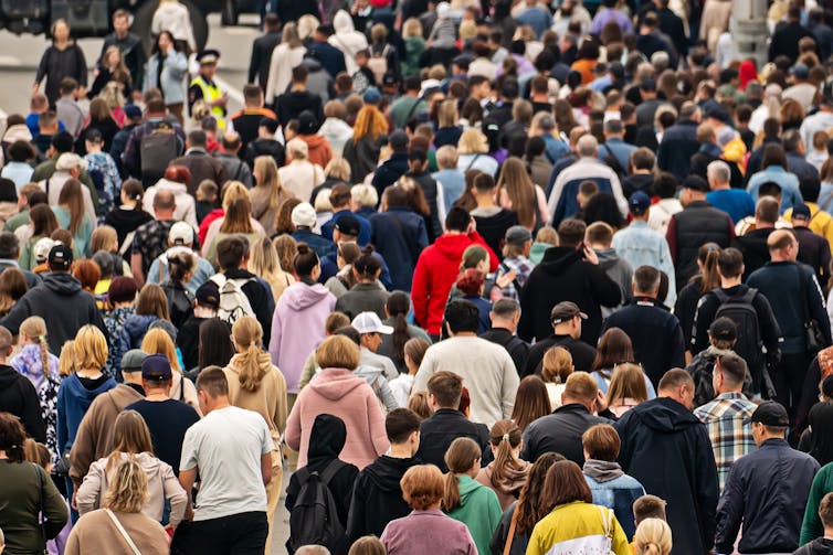 A huge crowd of people walking through a city.