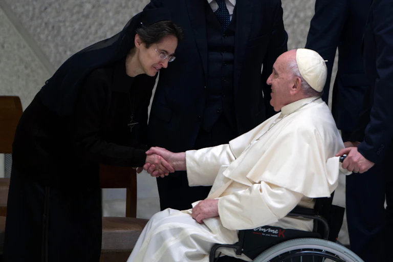 Pope Francis shakes hands with Sister Raffaella Petrini.
