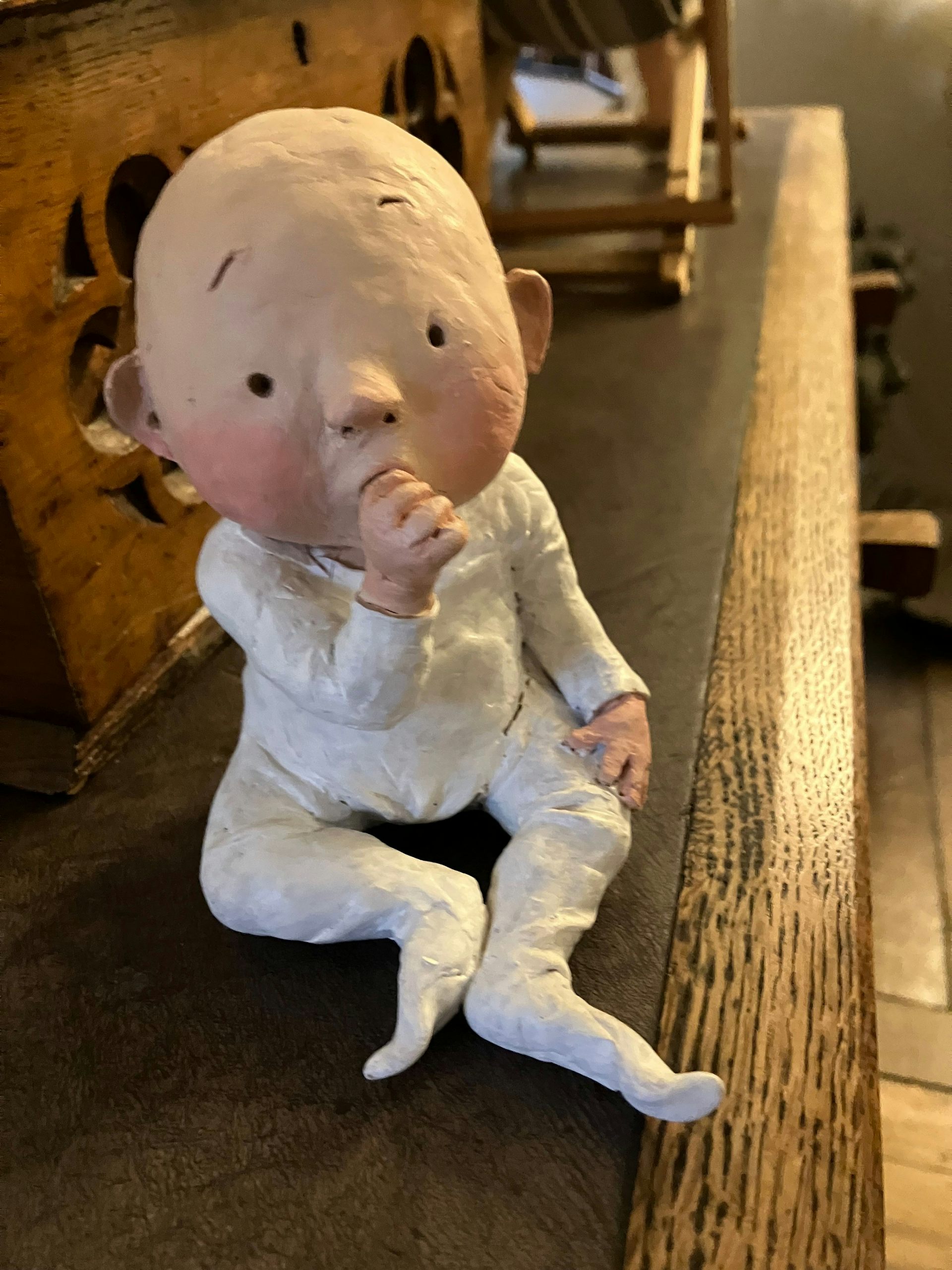 Clay model of a baby sucking its thumb