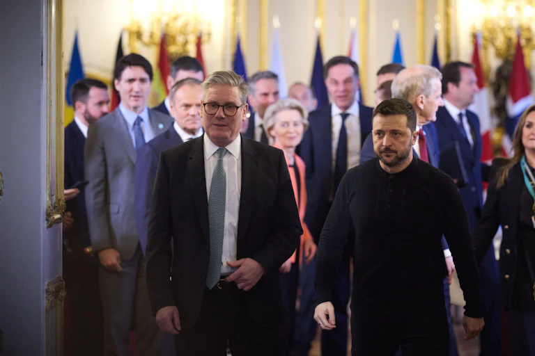 Keir Starmer and Vlodymyr Zelensky walk out of a room with other leaders.