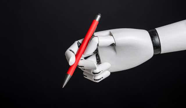 gray right robot hand holding a red pen