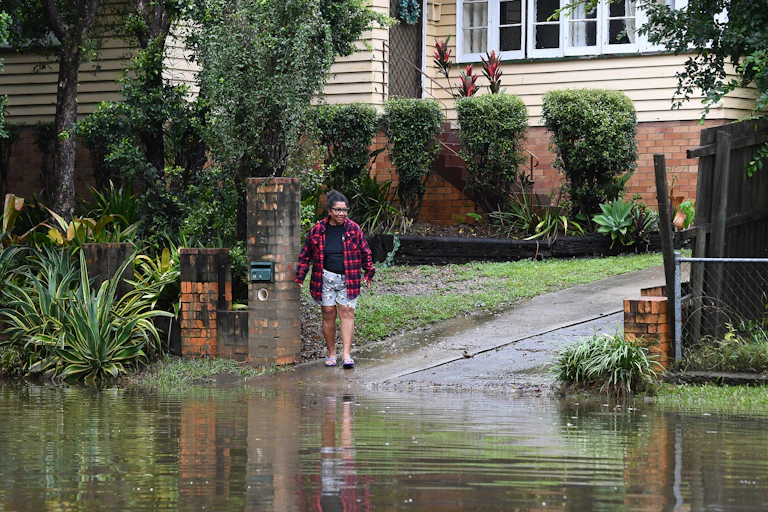 A resident looks at flooding on their street in Newmarket, in Brisbane on Monday