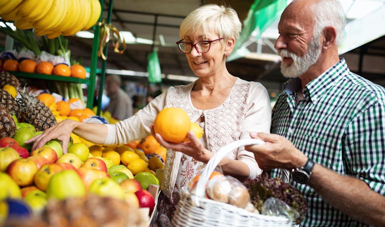 A senior couple shopping in a fruit market.