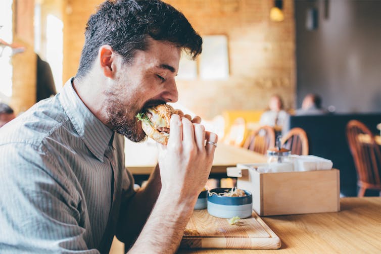 A man eating a burger in a restaurant.