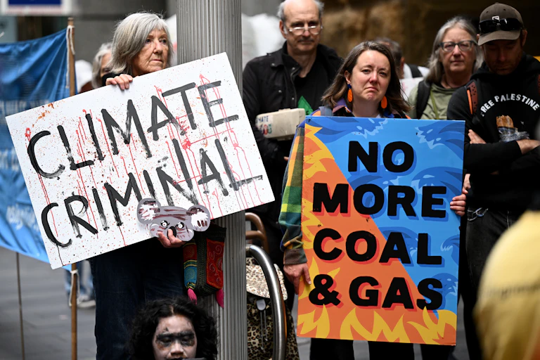 Protesters rally outside the Whitehaven Coal Annual General Meeting at Fullerton Hotel in Sydney, Wednesday, October 30, 2024. Signs read "Climate Criminal" and "No More Coal & Gas"