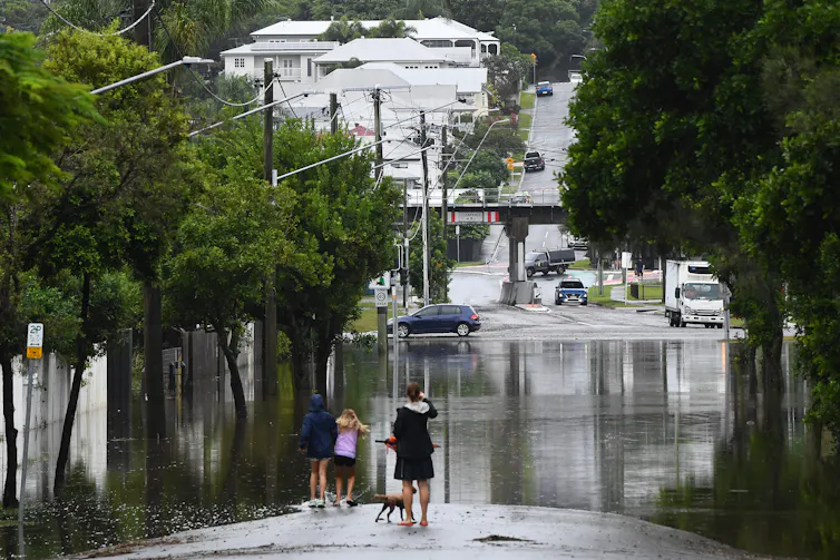 Residents look at flooding on their street in Newmarket, in Brisbane.
