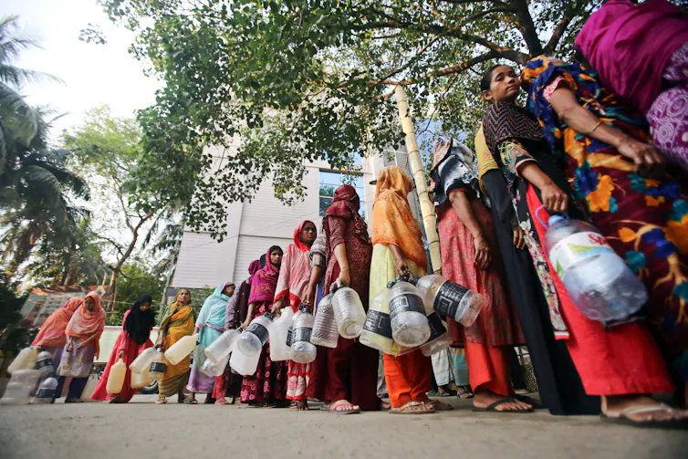 People in Bangladesh queue to collect drinking water from the Basabo Temple in Dhaka during the 2024 heatwave.