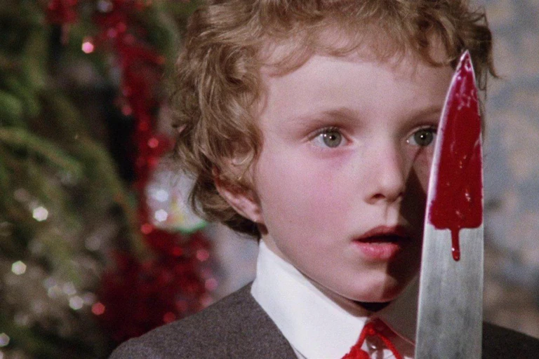 Un niño observa un cuchillo manchado de sangre.