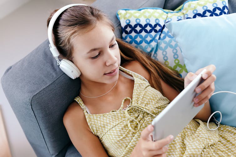 Girl wearing headphones on tablet