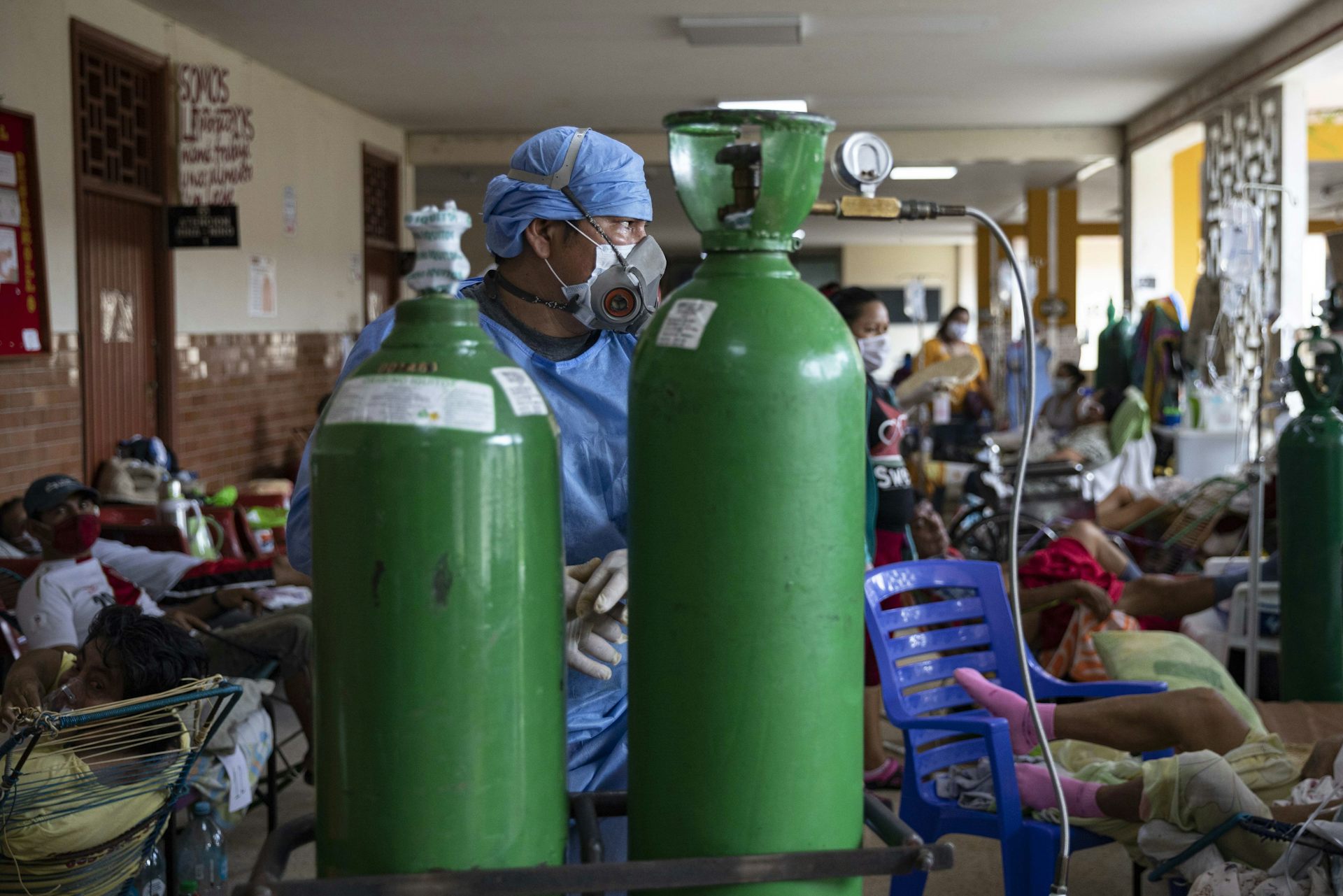 A doctor in front of two oxygen tanks in Iquitos, Peru.