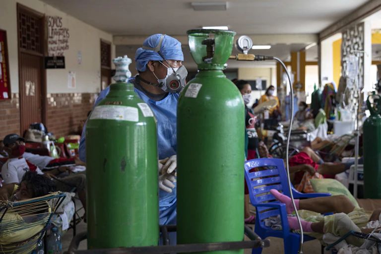 A doctor in front of two oxygen tanks in Iquitos, Peru.