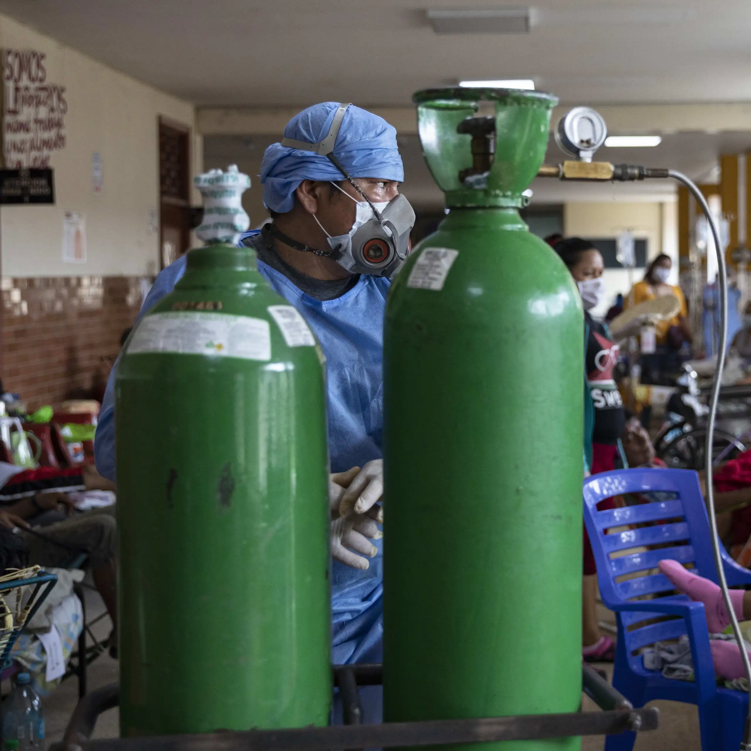 A doctor in front of two oxygen tanks in Iquitos, Peru.