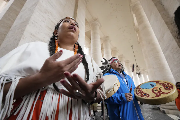 A person singing and another drumming.