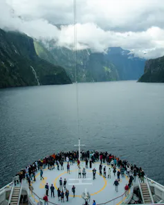 Passengers gatehr on deck of a cruise ship in Milford Sound