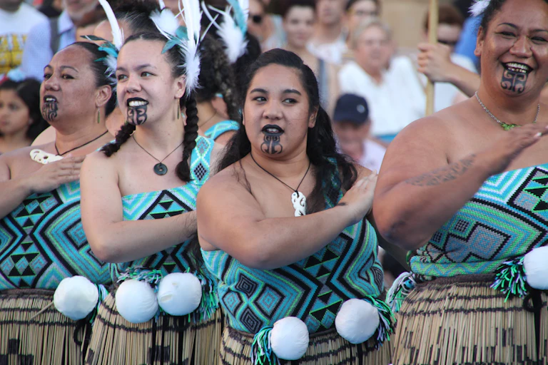Women in traditional Māori dress perform to a crowd