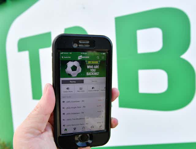 The TAB betting app is seen on a mobile phone outside a Tabcorp venue