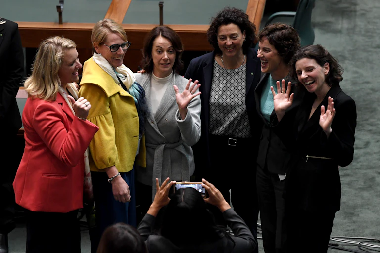 Six female independent MPs standing and posing for a photograph on the floor of parliament