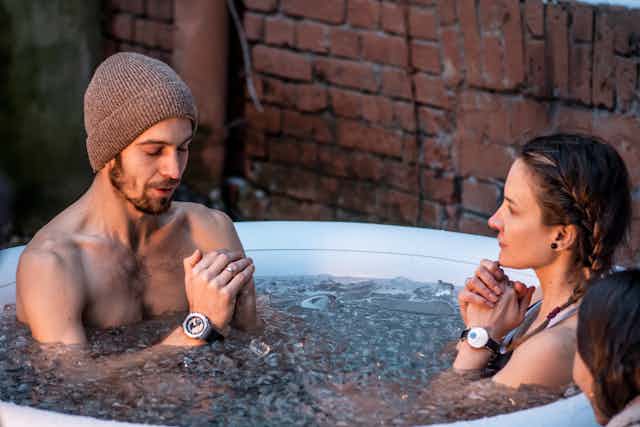 A man and a woman in an ice bath.