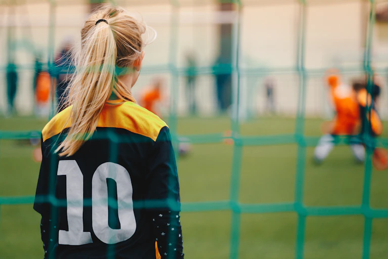 A young woman stands in goal during a soccer game